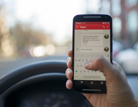 a hand holding a phone in a car